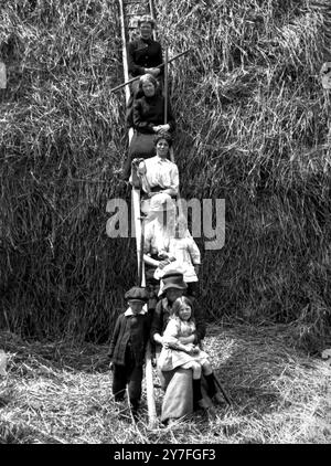 Le donne aiutano un contadino del Norfolk con il fieno Foto Stock