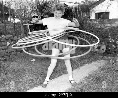 Facilmente la campionessa mondiale di maratona hula-hoop è l' undicenne Ann Evans di Glamorgan, Galles del Sud, che può tenere sette cerchi contemporaneamente. Ann sostiene di aver fatto girare il cerchio 33 , 550 volte in cinque ore e cinque minuti . 11 novembre 1958 Foto Stock