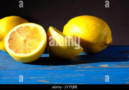 limoni gialli su un piano da tavolo dipinto di blu Foto Stock