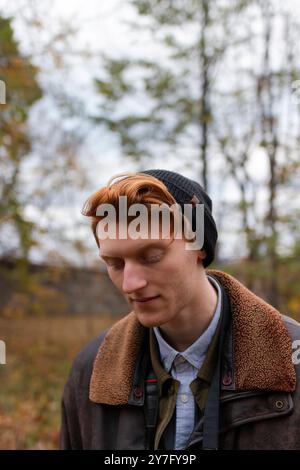 un uomo con i capelli di zenzero si vede indossare un berretto e una giacca calda Foto Stock