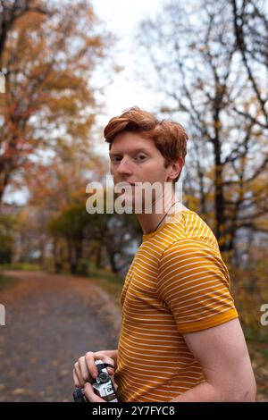 Un giovane uomo con una camicia a righe si trova su un percorso tortuoso Foto Stock