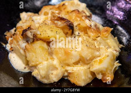Un delizioso piatto di patate Chorizo al forno in un posto nero Foto Stock