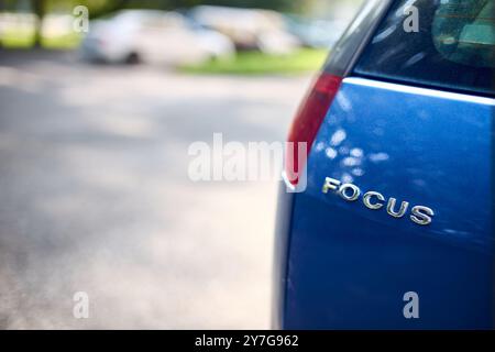 Minsk, Bielorussia - 24 agosto 2024: Modello Ford Focus del marchio tedesco Ford logo posteriore scudo logo logo logo logo logo logo logo primo piano selettivo ripresa in un parcheggio fuori fuoco Foto Stock