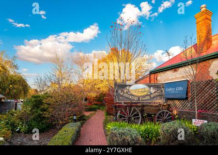 Villaggio tedesco di Hahndorf, Adelaide Hills, Australia del Sud - 1° maggio 2021: Cartello del vecchio mercato del villaggio di Hahndorf sul carrello d'epoca nel giardino autunnale visto da Foto Stock