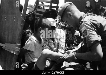 IL SOLDATO DELL'ESERCITO TRATTA UN BAMBINO PICCOLO CON FERITA DA ARMA DA FUOCO A PIYENIA, CIPRO; 4 LUGLIO 1964 Foto Stock