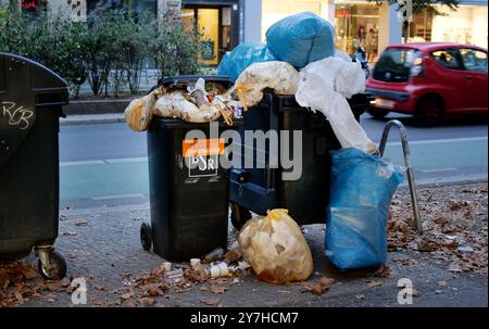 Berlino, Germania. 8 settembre 2024. 08.09.2024, Berlino. Traboccanti di rifiuti per rifiuti commerciali si trovano in una strada di negozi a Steglitz. I sacchetti di plastica pieni di rifiuti si trovano accanto ad essi. Credito: Wolfram Steinberg/dpa credito: Wolfram Steinberg/dpa/Alamy Live News Foto Stock