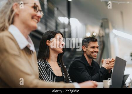 Felice giovane professionista donna con colleghi che lavorano in ufficio Foto Stock