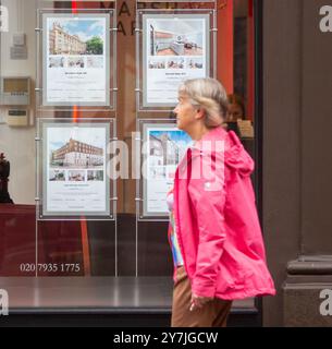 Londra, Inghilterra, Regno Unito. 30 settembre 2024. Si vedono persone che passano davanti a un'agenzia immobiliare nel centro di Londra. I prezzi delle case nel Regno Unito stanno crescendo al tasso annuo più rapido per quasi due anni, poiché i costi di prestito continuano a scendere secondo le aspettative che la Banca d'Inghilterra continuerà a tagliare i tassi di interesse,ha annunciato Â edificio nazionale societyÂ. I prezzi sono cresciuti del 3,2% a settembre rispetto allo stesso mese dello scorso anno, ben al di sopra del 2,4% di crescita annuale registrato ad agosto, e il ritmo più veloce dal 4,4% registrato a novembre 2022. (Credit Image: © Tayfun Salci/ZUMA Press Wire) USO EDITORIALE Foto Stock