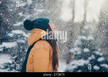 Foto di funky giocosa studentessa indossare giacca a vento sollevamento lingua degustazione neve foresta di campagna Foto Stock