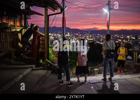 La gente gode delle vedute notturne di Kyoto dal punto di osservazione del tempio Fushimi Inari Taisha, Kyoto, Giappone Foto Stock