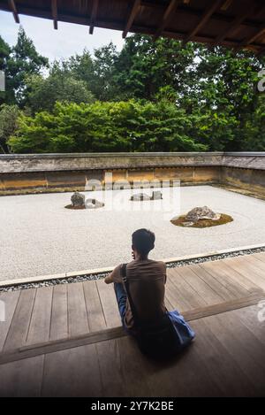 Un uomo medita nel giardino zen giapponese, il tempio Ryoan-Ji a Kyoto Foto Stock