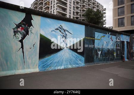 Graffiti raffiguranti questioni politiche, ambientali e sociali viste sul muro di Berlino costruito dai tedeschi dell'Est nel 1961 per circondare Berlino Ovest. Foto Stock