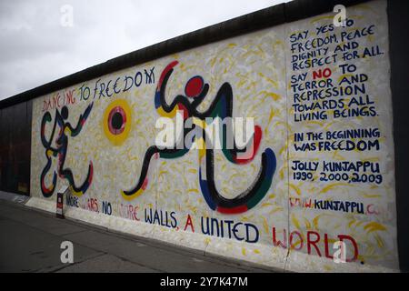 Graffiti raffiguranti questioni politiche, ambientali e sociali viste sul muro di Berlino costruito dai tedeschi dell'Est nel 1961 per circondare Berlino Ovest. Foto Stock