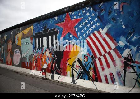 Graffiti raffiguranti questioni politiche, ambientali e sociali viste sul muro di Berlino costruito dai tedeschi dell'Est nel 1961 per circondare Berlino Ovest. Foto Stock