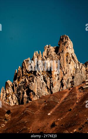 Un'impressionante vetta rocciosa sotto un cielo blu limpido, che mostra l'aspra bellezza naturale del paesaggio. Foto Stock