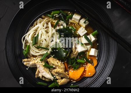 Cucina giapponese, spaghetti udon con pollo, alghe e formaggio tofu. Zuppa di miso. Primo piano. Foto di alta qualità Foto Stock