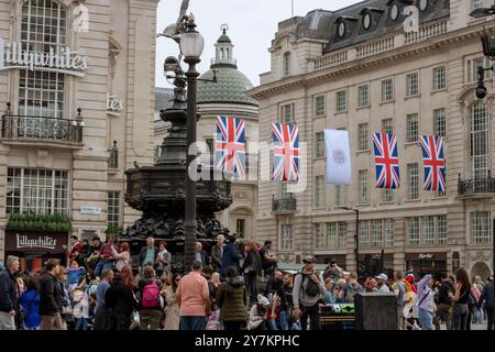 Londra, Inghilterra, aprile 30 2023: Londra, Inghilterra, aprile 30 2023: Ampia vista di Piccadilly Circus accanto alla statua di Eros e alle bandiere del Regno Unito Foto Stock