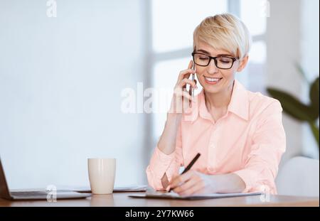 Donna Imprenditore Che Parla Sul Telefono Prendere Appunti Seduti Sul Posto Di Lavoro Foto Stock