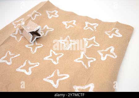 Come realizzare carta da imballaggio personalizzata, facile da realizzare per i bambini, carta marrone con motivi bianchi, rotolo di carta igienica piegato, Foto Stock