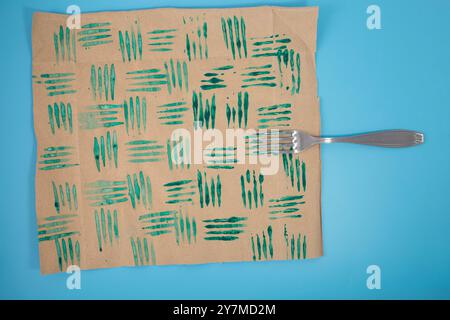 Esercitazione di timbri decorativi con forchetta e vernice, carta da imballaggio personalizzata fai da te. Attività creativa natalizia per i bambini, realizzando disegni unici su carta con materiali semplici per il divertimento delle feste. Foto Stock