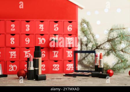 Cosmetici decorativi con calendario dell'Avvento di Natale in tavola, primo piano Foto Stock