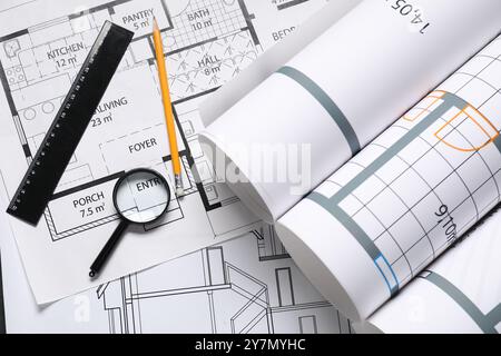 Diversi disegni architettonici, matita, righello e lente d'ingrandimento su tavolo bianco, piatto Foto Stock