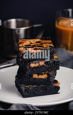 Pila di brownie al cioccolato scuro con una turbolenza al caffè vietnamita: Brownie fudgy realizzati con cacao nero in polvere e una turbolenza di caffè più leggera Foto Stock