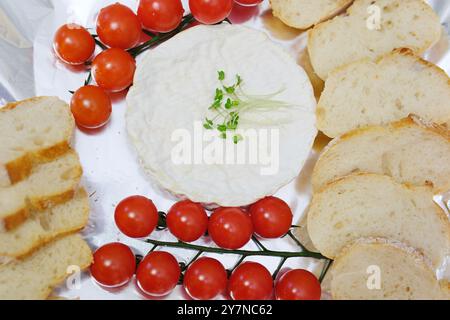 Cucinare camembert con crostini nel forno. Aggiungere olio. Camembert al forno con salsa all'aglio e spezie. Il formaggio si allunga, gocciola. brie fatta in casa nel forno. ricetta passo dopo passo Foto Stock