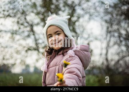 vista ravvicinata di una bambina con un cappello da unicorno che tiene in mano i leoni gialli Foto Stock