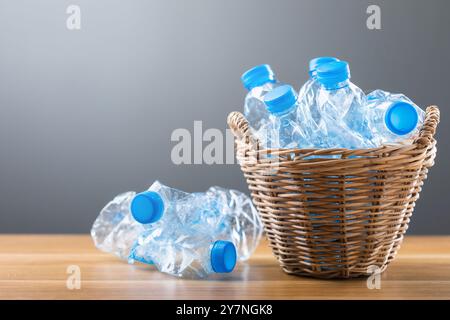 Vecchie bottiglie d'acqua collocate in un cestello su un tavolo, che rappresentano il concetto di separazione e riciclaggio dei rifiuti. Smistamento dei rifiuti e promozione dell'ambiente Foto Stock