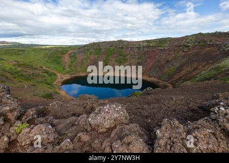 Una vista mozzafiato del lago Kerid Crater in Islanda sotto un cielo parzialmente nuvoloso. Foto Stock