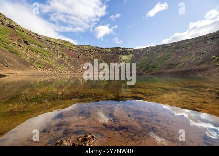 Una vista panoramica del lago Kerid Crater in Islanda con acque cristalline che riflettono le formazioni rocciose vulcaniche Foto Stock