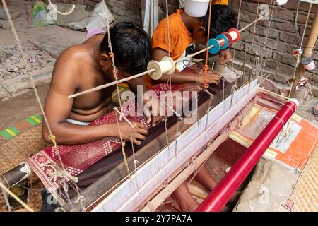 Narayanganj, Dacca, Bangladesh. 1 ottobre 2024. I tessitori fanno il sari Jamdani su un telaio a Narayanganj, Bangladesh. Jamdani è uno dei migliori tessuti in muslino del Bengala, prodotto nel distretto di Dhaka, Bangladesh per secoli. La produzione storica di jamdani fu patrocinata dai mandati imperiali degli imperatori moghul. Sotto il colonialismo britannico, le industrie bengalesi Jamdani e muslin diminuirono rapidamente a causa delle politiche di importazione coloniali che favorivano i tessili industriali. Negli ultimi anni, la produzione di Jamdani ha assistito a una ripresa in Bangladesh. Crediti: ZUMA Press, Inc./Alam Foto Stock