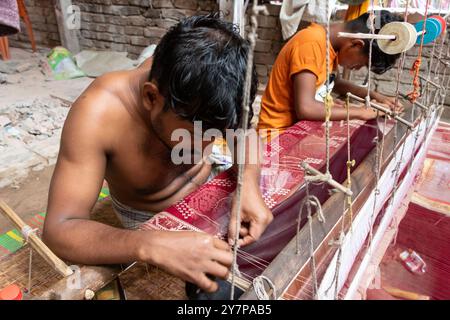 Narayanganj, Dacca, Bangladesh. 1 ottobre 2024. I tessitori fanno il sari Jamdani su un telaio a Narayanganj, Bangladesh. Jamdani è uno dei migliori tessuti in muslino del Bengala, prodotto nel distretto di Dhaka, Bangladesh per secoli. La produzione storica di jamdani fu patrocinata dai mandati imperiali degli imperatori moghul. Sotto il colonialismo britannico, le industrie bengalesi Jamdani e muslin diminuirono rapidamente a causa delle politiche di importazione coloniali che favorivano i tessili industriali. Negli ultimi anni, la produzione di Jamdani ha assistito a una ripresa in Bangladesh. Crediti: ZUMA Press, Inc./Alam Foto Stock