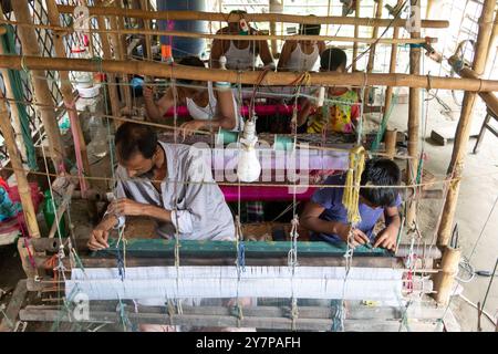 Narayanganj, Dacca, Bangladesh. 1 ottobre 2024. I tessitori fanno il sari Jamdani su un telaio a Narayanganj, Bangladesh. Jamdani è uno dei migliori tessuti in muslino del Bengala, prodotto nel distretto di Dhaka, Bangladesh per secoli. La produzione storica di jamdani fu patrocinata dai mandati imperiali degli imperatori moghul. Sotto il colonialismo britannico, le industrie bengalesi Jamdani e muslin diminuirono rapidamente a causa delle politiche di importazione coloniali che favorivano i tessili industriali. Negli ultimi anni, la produzione di Jamdani ha assistito a una ripresa in Bangladesh. Crediti: ZUMA Press, Inc./Alam Foto Stock