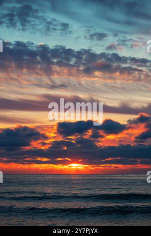 Bellissimo paesaggio nuvoloso sul mare, scatto verticale all'alba Foto Stock