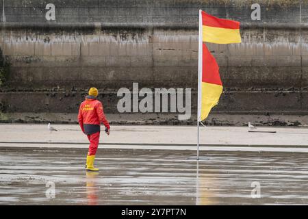 Un bagnino RNLI in servizio a piedi sulla spiaggia di Towan a Newquay in Cornovaglia nel Regno Unito. Foto Stock