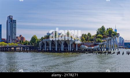 Little Island, costruita in cima ai pilastri in cemento del "Tulip Pot"; il quartiere Meatpacking di New York e Lower Manhattan sullo sfondo; vista dal molo 57. Foto Stock