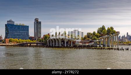 Little Island, costruita in cima ai pilastri in cemento del "Tulip Pot"; il quartiere Meatpacking di New York e Lower Manhattan sullo sfondo; vista dal molo 57. Foto Stock