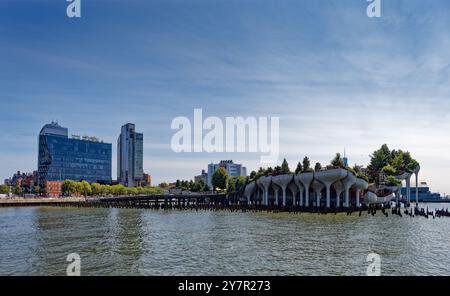 Little Island, costruita in cima ai pilastri in cemento del "Tulip Pot"; il quartiere Meatpacking di New York e Lower Manhattan sullo sfondo; vista dal molo 57. Foto Stock