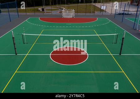 Un campo ben tenuto progettato per pallavolo e pallamano, con marcature vivaci. Foto Stock