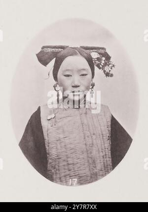 Foto vintage di coiffure cinese femminile. Questa foto rappresenta la coiffure di matrons manciù o tartaro sposati. La base del dispositivo è costituita da una striscia piatta di legno, avorio o metallo prezioso lungo circa un piede. Metà dei veri capelli di chi lo indossa viene raccolto e attorcigliato in fasce larghe intorno a questo supporto, che viene quindi appoggiato sul retro della testa. Foto Stock