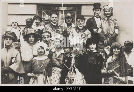 Le persone si sono riunite fuori da un edificio indossando vari costumi, alcuni in trascinamento. Cartolina fotografica, 1924 gli attori, che interpretano una varietà di personaggi, sono in primo piano per questo ritratto di gruppo. Probabilmente un gala in abito elegante piuttosto che una produzione teatrale, in una location non identificata (britannica). Palle in costume e gala godettero di una particolare voga negli anni '1920 Uomini e donne sono entrambi vestiti in croce Foto Stock