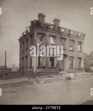 Foto d'epoca della guerra delle ferrovie a Pittsburgh, dal 21 al 22 luglio 1877. Pan-Handle R. Office su Seventh Avenue. Il fuoco e' finito qui, Pittsburgh, Pennsylvania. STATI UNITI. 1877 lo sciopero ferroviario di Pittsburgh avvenne a Pittsburgh, Pennsylvania, come parte del Great Railroad Strike del 1877. Fu uno dei tanti incidenti di scioperi, disordini sindacali e violenze in città in tutti gli Stati Uniti, tra cui diversi in Pennsylvania. Altre città che si trovavano a fronteggiare simili disordini includevano Filadelfia, Reading, Shamokin e Scranton. Gli incidenti hanno fatto seguito a ripetute riduzioni salariali e talvolta a aumenti del carico di lavoro di Foto Stock