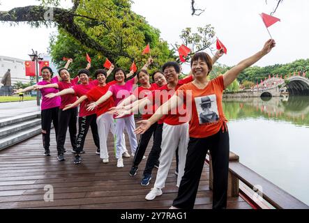 Pechino, la provincia cinese del Fujian. 1 ottobre 2024. Le persone che detengono bandiere nazionali posano per una foto su una piazza del Fujian Museum di Fuzhou, nella provincia del Fujian, nel sud-est della Cina, 1 ottobre 2024. Il 75° anniversario della fondazione della Repubblica popolare cinese è stato osservato martedì in vari modi in tutto il paese . Crediti: Wei Peiquan/Xinhua/Alamy Live News Foto Stock