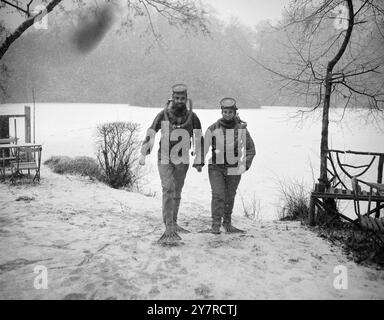 ABBIAMO DORMITO NEL GHIACCIO. Ogni domenica un gruppo di appassionati che indossano le loro tute da esposizione si tuffano nelle acque ghiacciate di Laughing Water Creek, Dartford, Kent. Ma oggi, prima di potersi godere la nuotata, hanno dovuto rompere il ghiaccio denso. SPETTACOLI FOTOGRAFICI I.N.P. Miss Pauline M. Ady, 24 anni, di Teddington, che va a nuotare in un apparato Foto Stock