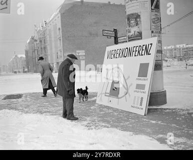 BERLINO OVEST SI PREPARA ALLA GRANDE CONFERENZA 1.24.54. Il traffico è stato deviato intorno all'edificio dell'ex Allied Control Authority, dove si terranno le prime e le terza settimane della Big Four Conference. La foto dell'INP mostra un vecchio berlinese, con il suo cagnolino, che sembra piuttosto perplesso davanti a un poster delle strade bloccate intorno all'edificio della conferenza. Il poster che mostra l'area ombreggiata chiusa ai berlinesi durante la conferenza si trova all'angolo tra Haupt- e Schwäbische Strasse vicino all'edificio ACA. Foto di notizie internazionali di Joe Waldorf 21.54. Foto Stock