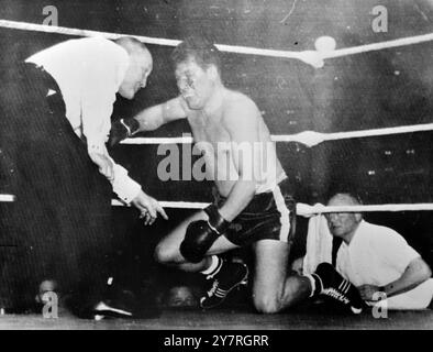 Il campione europeo dei pesi massimi cubani KO 19.11.53 Nino Valdes, il campione cubano di pugilato dei pesi massimi e terzo nelle classifiche mondiali, ha eliminato il tedesco Heinz Neuhaus, campione europeo, nel quarto round della lotta non titolata in Germania questa settimana. Una folla di 19.000 persone assistette alla lotta, che ebbe luogo a Dortmund Westfalenhalle. La foto INP mostra il campione tedesco, Heinz Neuhaus, che conta sulle ginocchia. Foto Stock