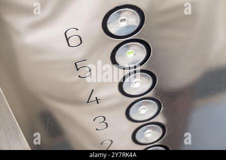 Bottoni rotondi in ascensore con coperchio metallico graffiato dopo anni di utilizzo Foto Stock