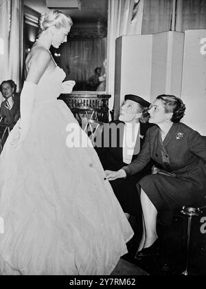 DAME EDITH DICE 'SQUISITO' 16.10.53. L'attrice britannica Dame Edith Evans ha partecipato a una sfilata di moda di stili autunnali e invernali presso Pierre Balmain's a Parigi mercoledì. È rimasta particolarmente colpita dalla collezione di abiti da palla che ha descritto come "abbastanza squisiti". La foto INP mostra Dame Edith Evans (al centro) che ammira un abito bianco di organdy alla mostra di Pierre Balmain. Foto di notizie internazionali. Foto Stock